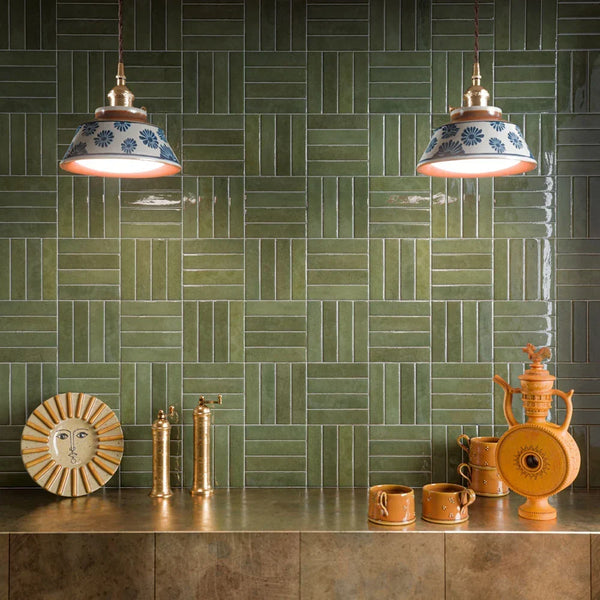Bathroom interior showcasing the Nomad tile collection, with sage green and oatmeal brick tiles in a herringbone layout, creating a calm, textural backdrop paired with natural stone and warm, contemporary styling.
