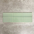 Pimlico Lime Green 15 × 15cm ceramic skirting tiles with a crackle glaze finish, featuring a soft green tone and moulded detail, designed to create a smooth transition between tiled walls and floors.