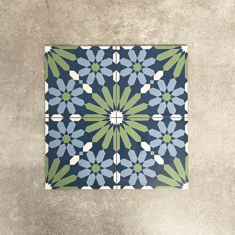 Fez Springs 20x20cm Moroccan-style porcelain tiles arranged as a four-tile panel, highlighting the full repeat design with layered blue and soft green geometric star motifs against a textured grey background.