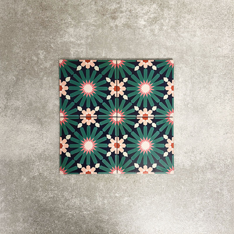 Fez Mini Festival 15x15cm Moroccan-style porcelain tile displayed against a textured grey background, highlighting the bold multicolour geometric star pattern in teal, pink and warm neutral tones.