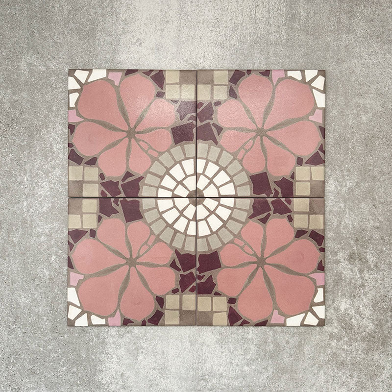 Nantes Rose Pink Moroccan-style patterned tiles laid in a seamless layout, showcasing soft pink floral motifs, cream circular medallion details, and mosaic-inspired geometric accents in muted neutrals and deep burgundy tones. The 20x20cm encaustic-style tiles create a decorative, vintage-inspired surface ideal for floors or feature walls.