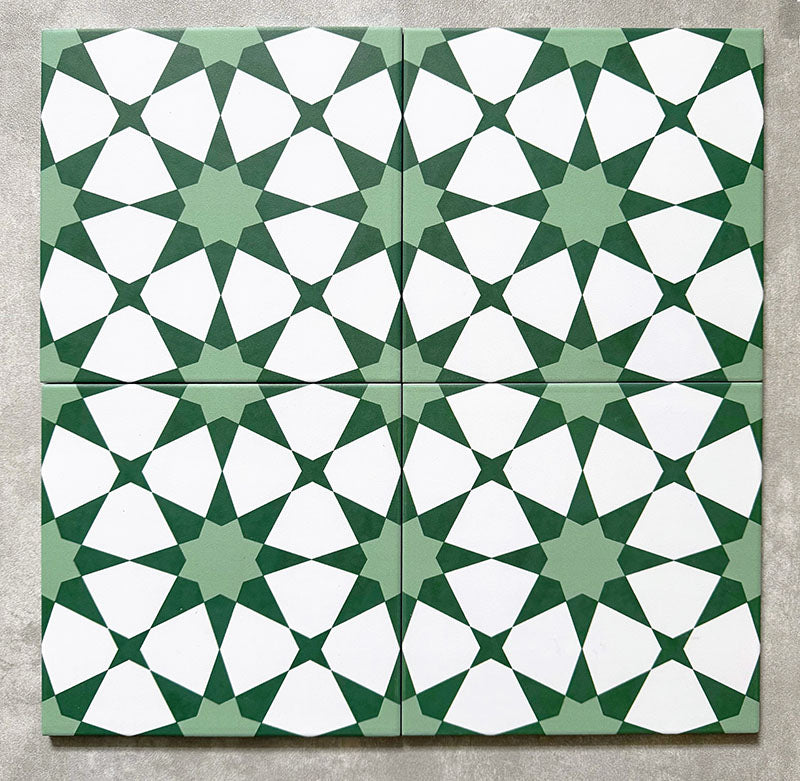 Agadir Green Moroccan-style 20x20cm porcelain tiles arranged as four tiles, showcasing a repeating geometric star pattern in green and white on a neutral background.