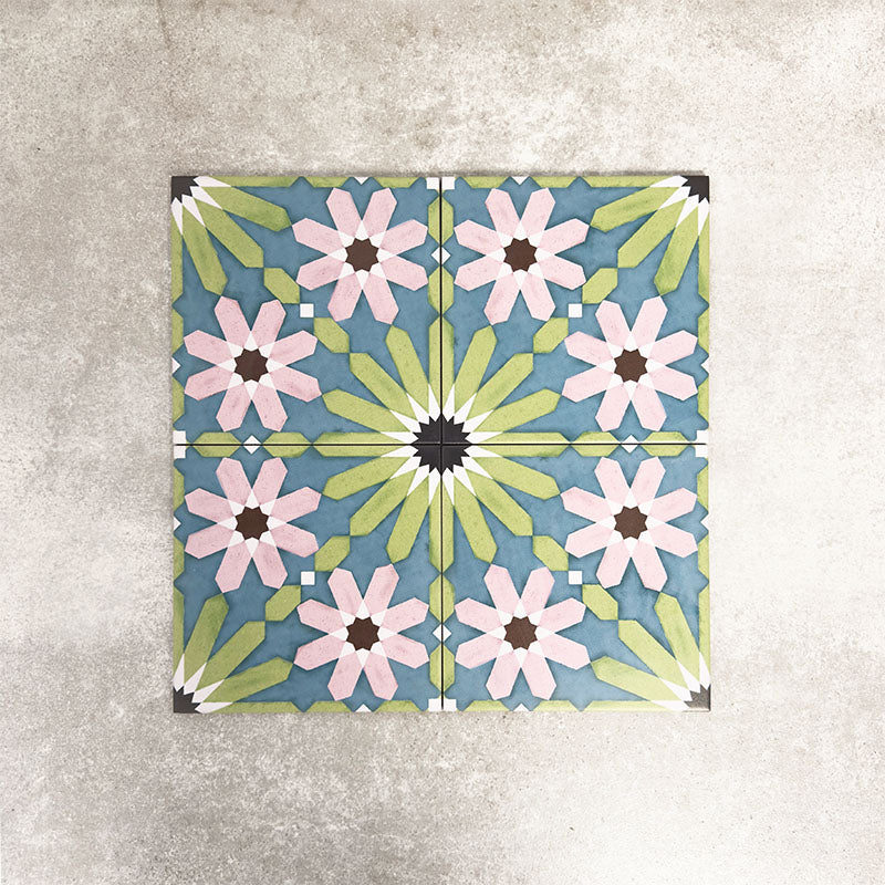 Fez Summer 20x20cm Moroccan-style porcelain tiles arranged as a four-tile panel, highlighting the full repeat design with soft green, blue and blush pink geometric star motifs against a textured grey background.