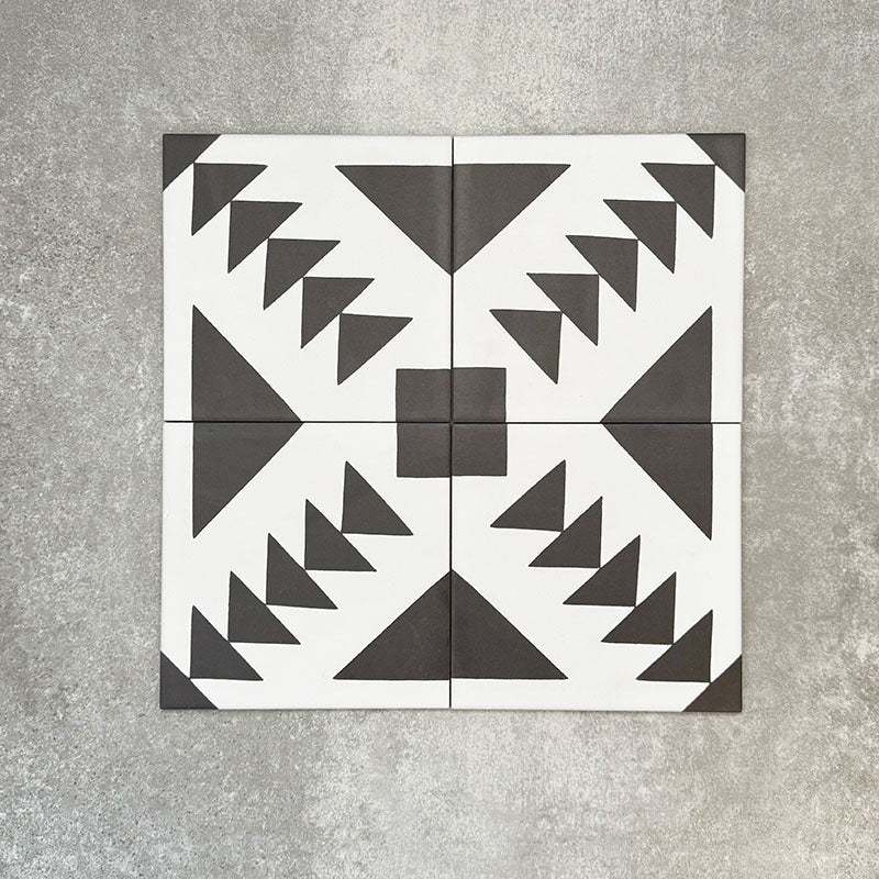 Almeira Azteca Moroccan-style porcelain floor tiles arranged in a four-tile layout, showcasing a bold black and white geometric pattern with stepped triangles and central detailing, 20x20cm.