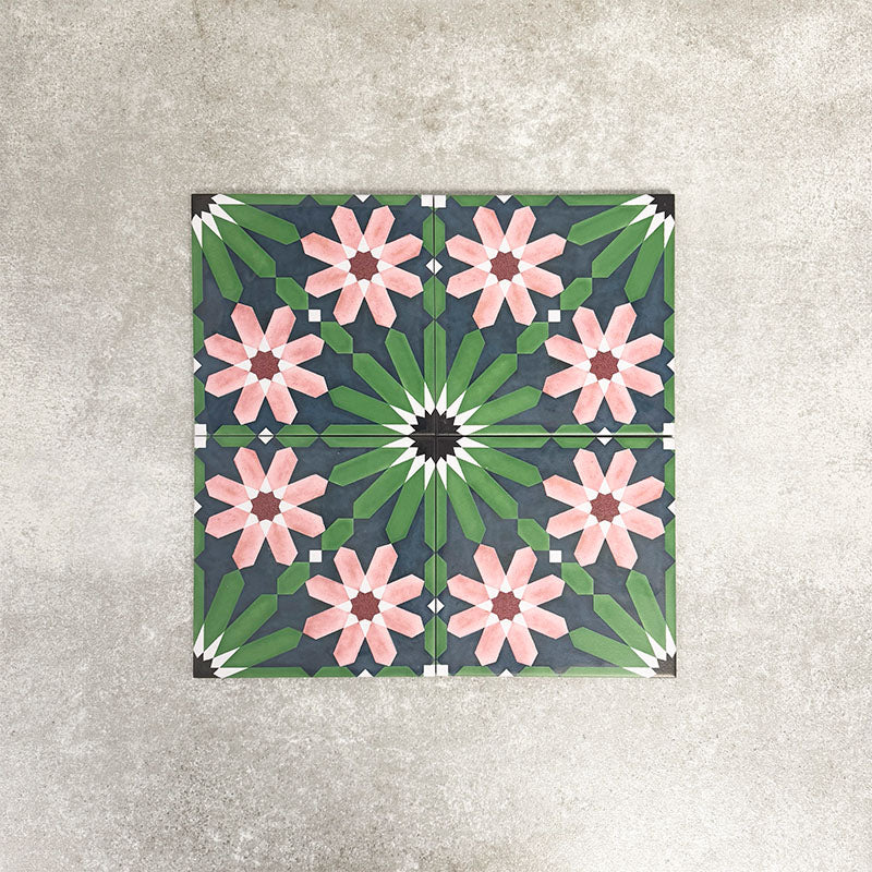 Four-tile layout of Fez Autumn Moroccan-style porcelain tiles, showing how the 20 × 20cm tiles come together to form a complete geometric motif. The design features soft blush-pink floral shapes, deep green leaf-like details and a charcoal background, creating a balanced, symmetrical pattern inspired by traditional Moroccan encaustic tiles.
