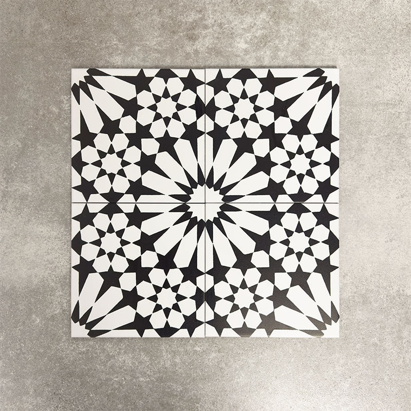 Fez Winter Moroccan-style porcelain tiles arranged as a four-tile pattern, forming a striking central star motif. The 20 × 20cm tiles feature a bold black and white geometric design with crisp lines and high contrast, showcasing the full encaustic-effect pattern when laid together. Ideal for statement floors, feature walls, and contemporary or monochrome interiors.