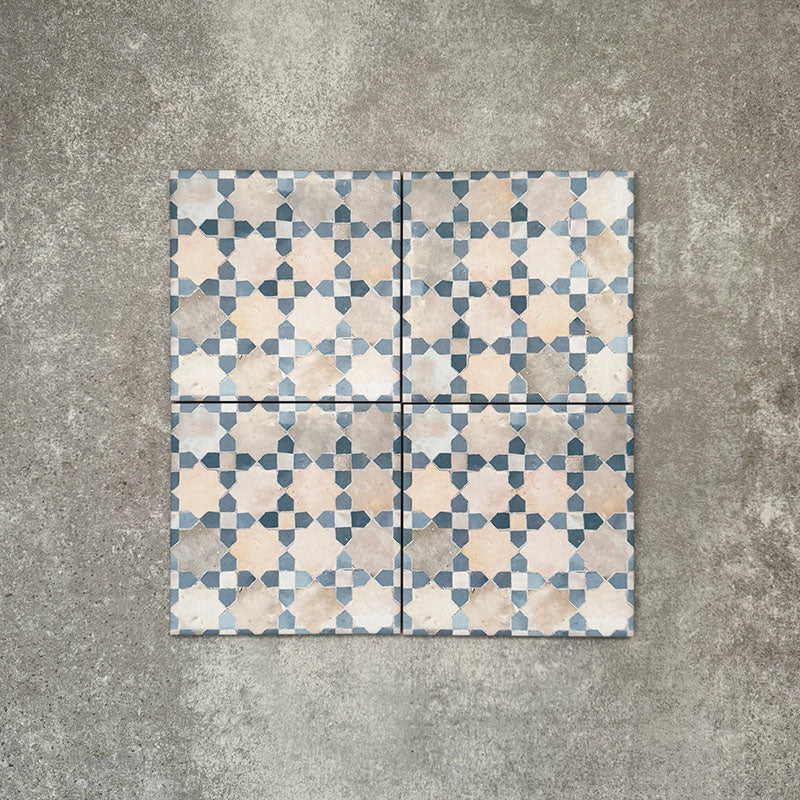 Four Berber Mequinez Blue 15×15cm Moroccan-style porcelain tiles arranged together, highlighting the soft blue and cream geometric pattern on a neutral background.