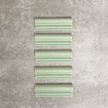 Pimlico Lime Green dado trim tiles measuring 5 × 15cm, finished with a crackle glaze and soft green tone, designed to add a decorative feature line and classic detail to ceramic wall tile installations.