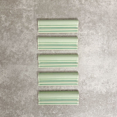 Pimlico Lime Green dado trim tiles measuring 5 × 15cm, finished with a crackle glaze and soft green tone, designed to add a decorative feature line and classic detail to ceramic wall tile installations.