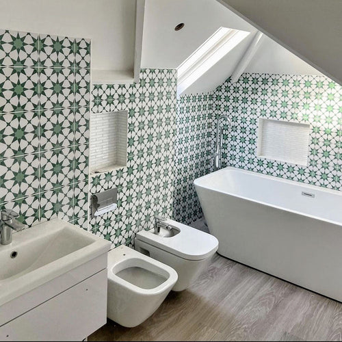 Bathroom interior featuring Agadir Green Moroccan-style 20x20cm porcelain wall tiles, showcasing a repeating geometric star pattern in green and white, styled with a freestanding bath, modern sanitaryware and a bright, airy layout.