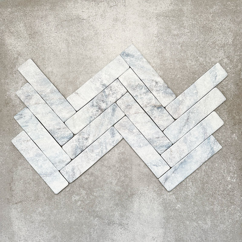 Product image of Amalfi Brick Azul Vintage Marble wall and floor tiles in a 5.4cm x 22cm format, arranged in a herringbone pattern, showcasing soft blue and white marble effect detailing with subtle veining and tonal variation.