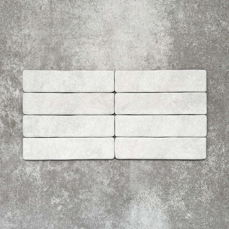 Product image of Amalfi Brick Carrara Vintage Marble wall and floor tiles in a 5.4cm x 22cm format, showcasing a soft white marble effect surface with subtle tonal variation.