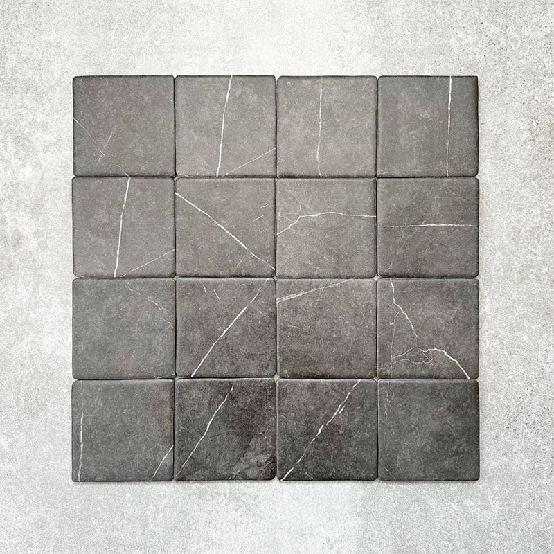 Product image of Amalfi Square Nero Vintage Marble wall and floor tiles in an 11cm x 11cm format, displaying a dark charcoal marble effect surface with subtle white veining and softly rounded edges.