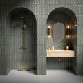 Bathroom vanity area featuring Baroque Decor Lichen Green 9.1x37.5cm porcelain wall tiles, showcasing a glossy fluted design in soft green tones, paired with a stone basin, brass fittings and warm ambient lighting.