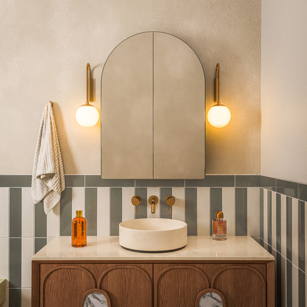 Contemporary bathroom featuring Baroque Vanilla porcelain wall tiles in a vertical stacked layout, paired with a burgundy and white chequerboard floor, walnut vanity, brushed brass fittings, an olive green WC and a striking red-framed shower enclosure for a bold, retro-inspired interior.