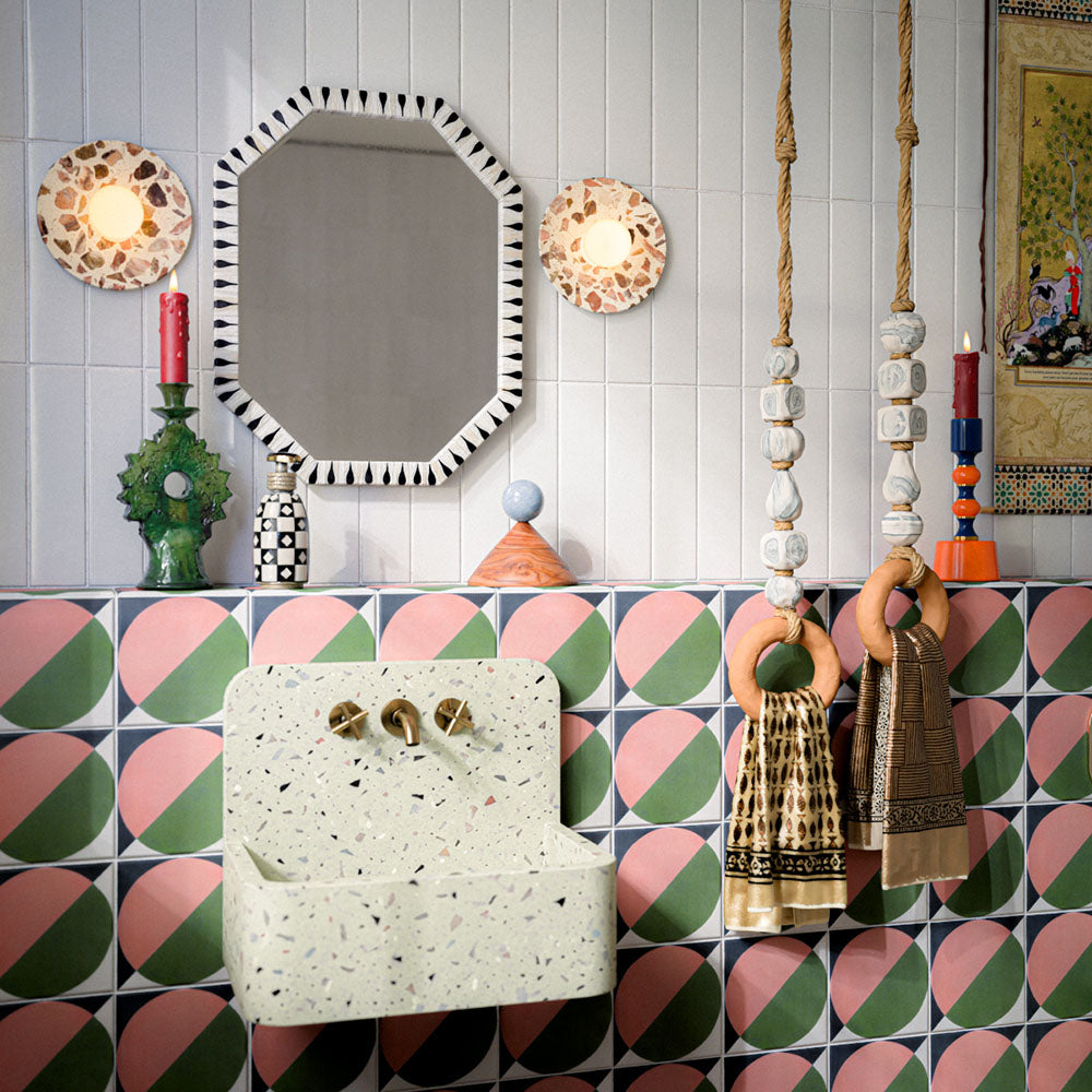 Bathroom featuring Baroque Vanilla 9.1x37.5cm porcelain wall tiles, paired with bold geometric patterned wall and floor tiles, terrazzo-effect basin, and eclectic décor for a playful contemporary interior.