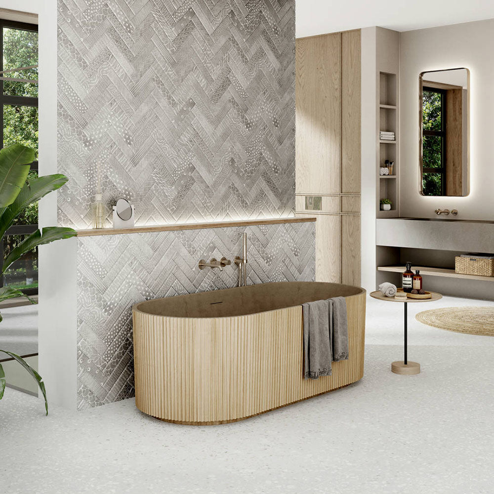 Modern bathroom featuring Gelato White 66x66cm terrazzo-style porcelain floor tiles, displaying a soft white base with subtle terrazzo flecks and styled with a freestanding bath, textured feature wall tiles and warm wood finishes for a calm, spa-inspired interior.