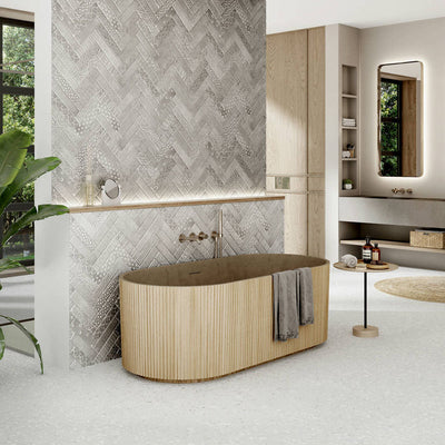 Modern bathroom featuring Gelato White 66x66cm terrazzo-style porcelain floor tiles, displaying a soft white base with subtle terrazzo flecks and styled with a freestanding bath, textured feature wall tiles and warm wood finishes for a calm, spa-inspired interior.