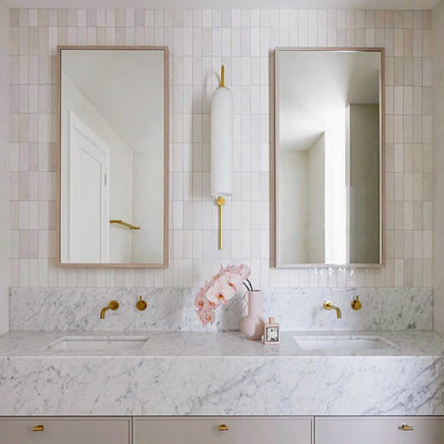 Benomar White Moroccan Mini Brick Gloss Tile 5x15cm used in a vertical stacked layout, featuring crisp white gloss tiles with subtle surface variation, styled in a contemporary bathroom with marble vanity and brass fixtures.