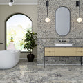 Bathroom interior featuring Fayrouz Picasso natural marble tiles with a honed finish, installed across the floor and wall in a mixed format layout, showcasing a white base with bold grey, green and warm gold veining for a cohesive, statement look with rich natural variation.