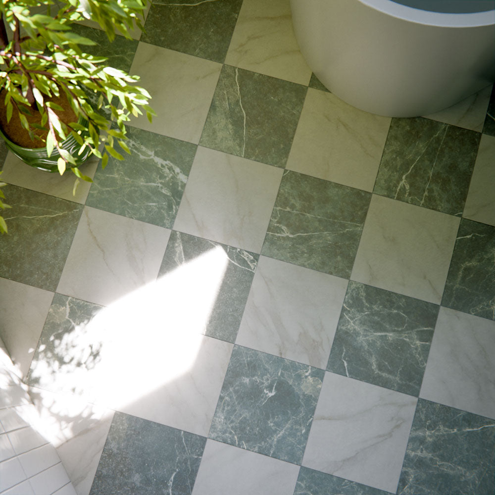 Bathroom floor featuring Vitoria Classic green marble-style porcelain chequerboard tiles in a 30 × 30cm format, combining rich green and soft white marble-effect squares laid in a classic pattern, enhanced by natural light, greenery, and a freestanding bath for a calm, elegant finish.