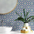 Bathroom vanity splashback featuring Fez Mini Artisan 15x15cm Moroccan-style porcelain tiles, showcasing a detailed multicolour geometric pattern in soft blue, blush pink, green and terracotta tones, styled with a round mirror, ceramic basin and natural accessories for a calm, decorative finish.