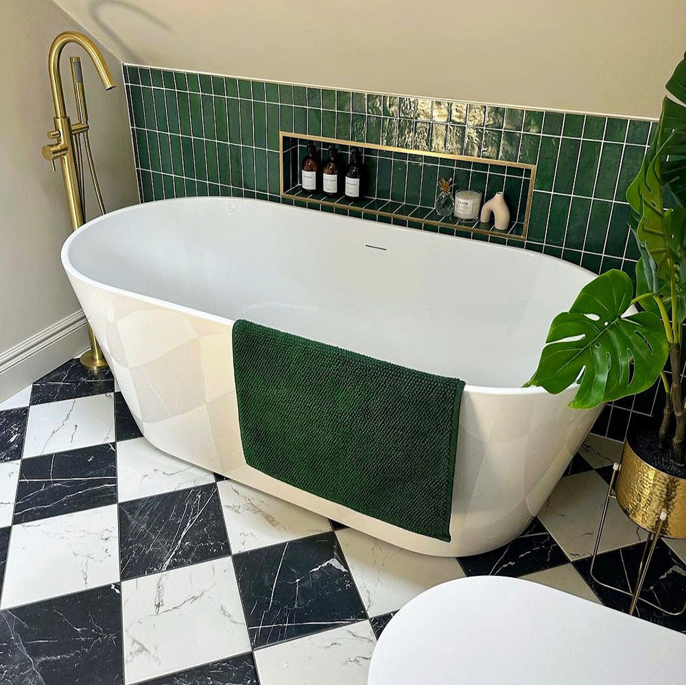 Bathroom featuring Florence Marquina Black 25x25cm marble-effect porcelain floor tiles laid in a classic black and white checkerboard pattern, styled with a freestanding bath, brass fittings and green tiled wall accents for a luxurious, spa-inspired look.