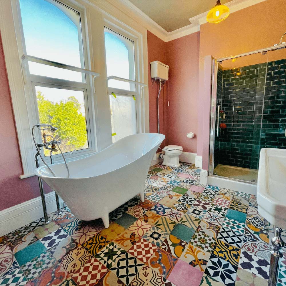 Bathroom interior featuring Fayrouz Patchwork 20×20cm Moroccan-style porcelain floor tiles, combining colourful geometric and floral patterns for a bold, decorative patchwork effect.