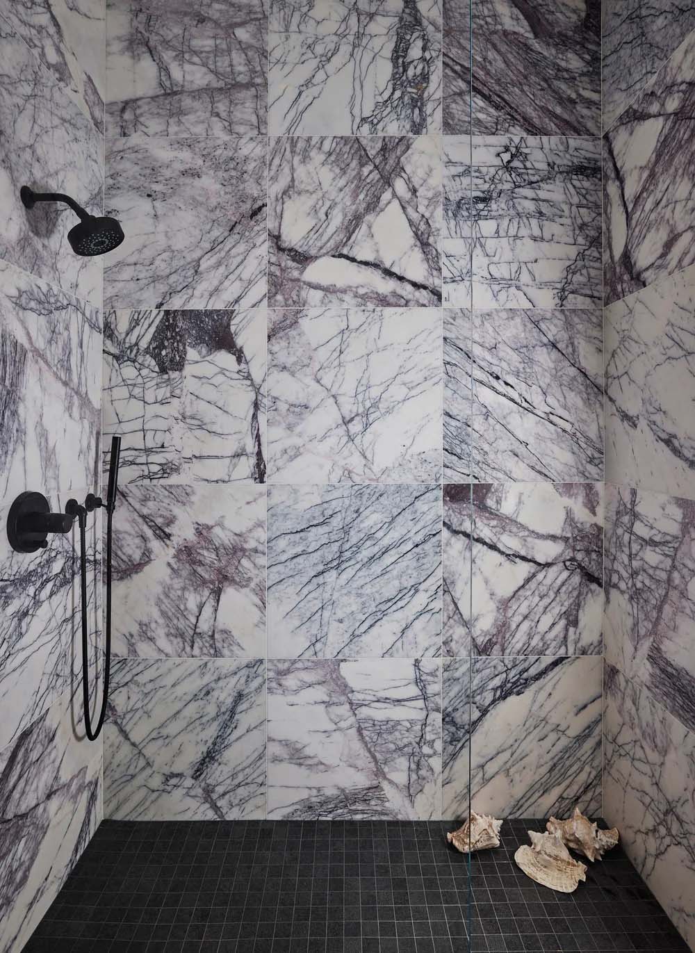 Shower interior featuring Fayrouz Lilac 30.5x61cm natural marble tiles with a honed finish, installed across the walls to showcase a white base with striking lilac and grey veining, creating a bold, immersive space with rich natural movement and variation.