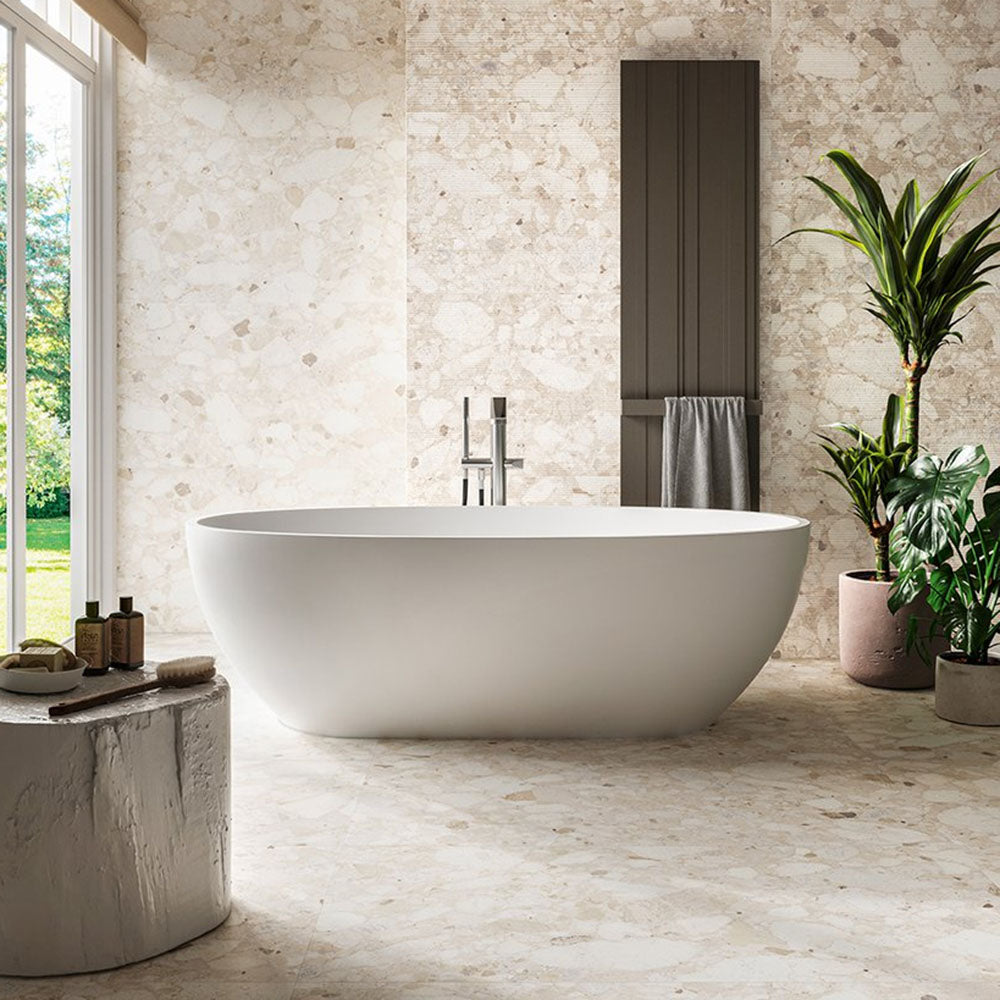 Bathroom featuring Venice Ivory terrazzo tiles in a matt finish, 60x60cm, creating a soft, natural floor and wall backdrop, styled with a freestanding bath, greenery and minimal spa-style accessories.