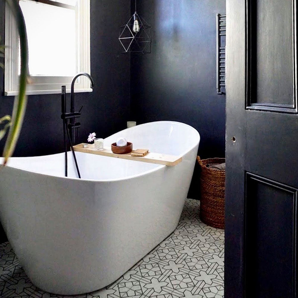 Bathroom featuring Almeria Palace Moroccan-style porcelain floor tiles in a refined black line geometric pattern, 20x20cm, paired with a freestanding bath and dark painted walls.