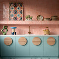 Kitchen featuring Benomar Pink Gloss 5x15cm Moroccan-style wall tiles in a geometric layout, styled with pastel blue cabinetry, brass fixtures, and decorative accents for a playful contemporary interior.
