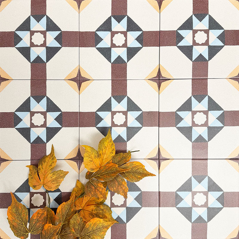 Group of London Streets Berlin Street 20x20cm Victorian Moroccan style porcelain tiles arranged to display the repeating geometric star pattern in burgundy, soft blue and cream tones, styled with autumn leaves in a decorative flat-lay setting.
