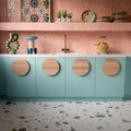 Kitchen featuring Byblos Cotton 60x120cm terrazzo-effect porcelain floor tiles, paired with blush pink Moroccan-style wall tiles, pastel blue cabinetry, and brass fixtures for a playful contemporary interior.