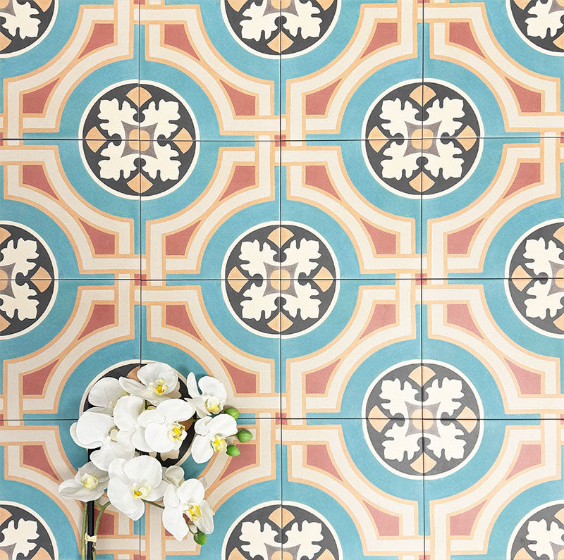 Group of London Streets Carnegie Hall 20x20cm Victorian Moroccan style porcelain tiles arranged together to showcase the repeating geometric pattern in teal, cream, terracotta and black tones, styled with white flowers for a decorative flat-lay setting.