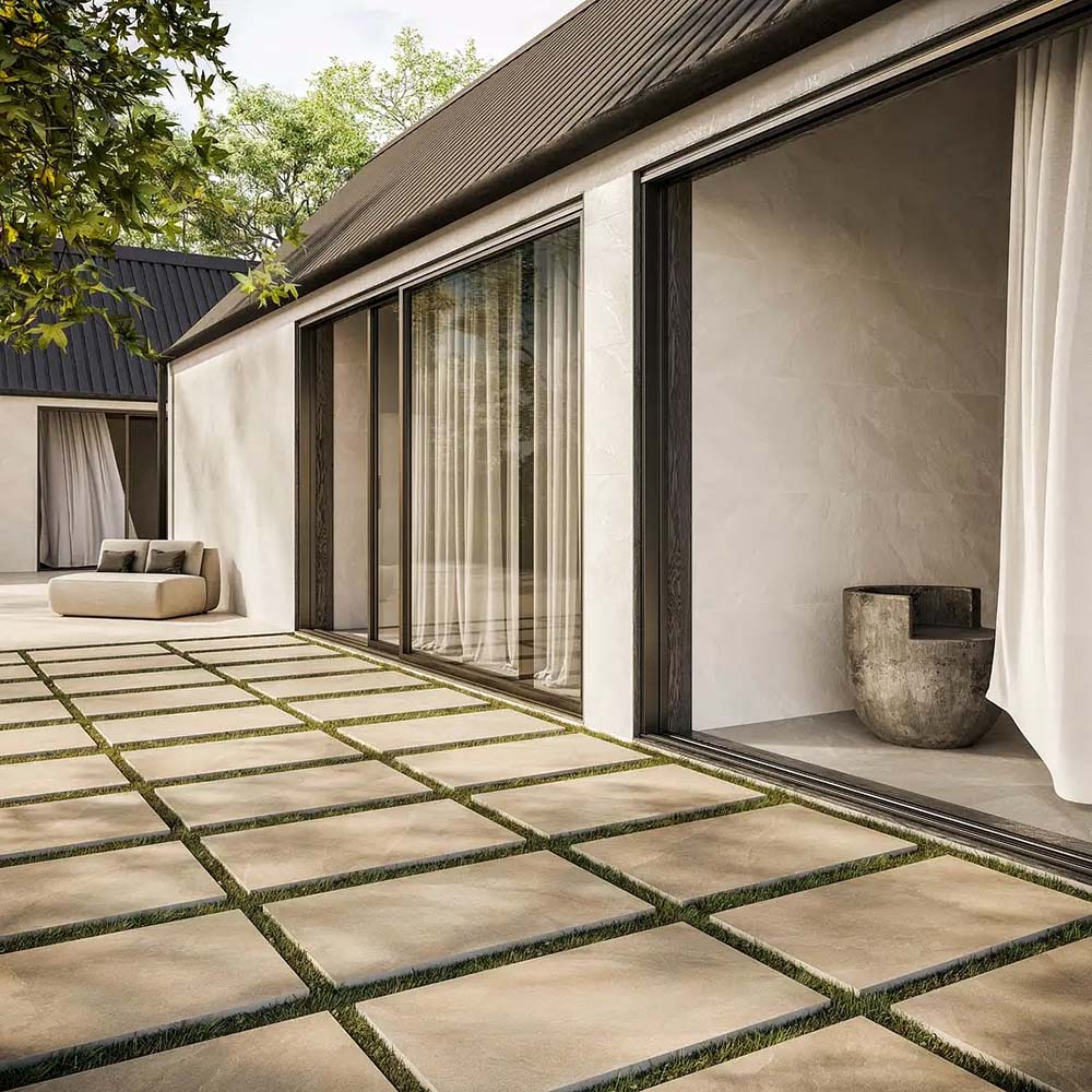Outdoor patio featuring Comet Light Stone 2cm 60 × 90cm porcelain tiles, laid with grass joints to soften the layout. Soft beige stone effect tones and subtle variation create a calm, contemporary outdoor space.