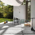 Outdoor patio setting featuring Comet Silver Stone 2cm 60 × 90cm porcelain tiles, laid in a modern grid with gravel joints. Soft silver-grey stone effect tones create a clean, contemporary look, complemented by minimalist furniture, greenery, and natural light.