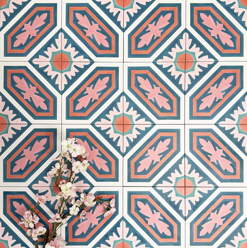 Group of London Streets Conduit Street 20x20cm Victorian Moroccan style porcelain tiles arranged to display the repeating pink, teal and terracotta geometric pattern, styled with delicate flowers in a decorative flat-lay setting.