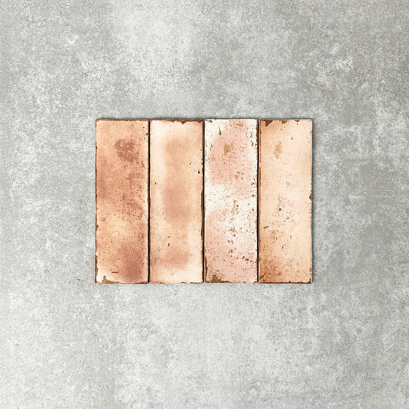 Close-up of Foundry Bricks Coral Pink 6.5x20cm brick wall tiles, showcasing warm blush and terracotta tones with subtle tonal variation, lightly textured surface and gently irregular edges for a refined, contemporary finish.