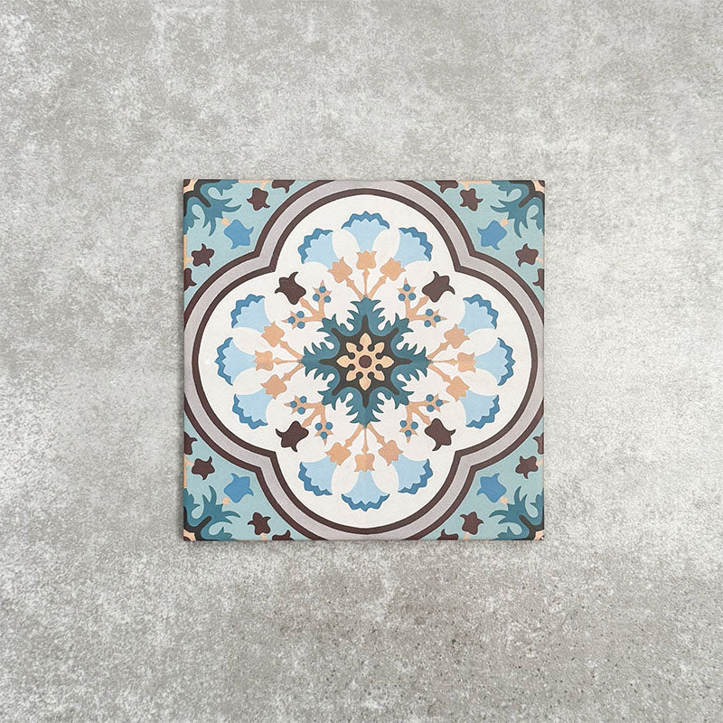 Cuba Bayamo Moroccan style patterned tile in a 20cm x 20cm format, featuring an ornate geometric floral design in soft blue, cream, teal and warm brown tones, displayed against a textured concrete-effect background.