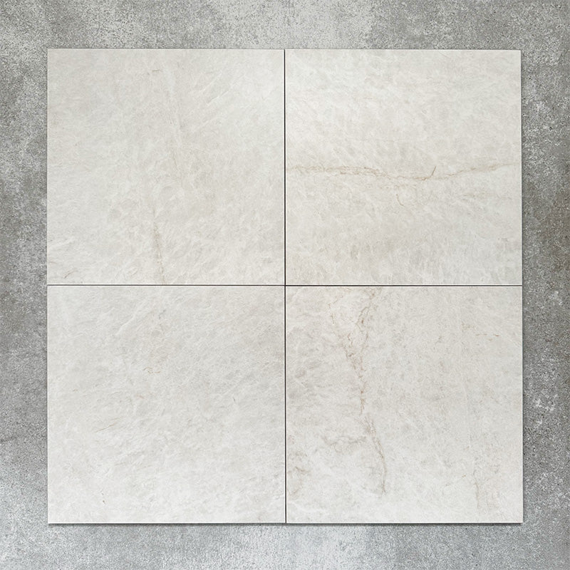 Close-up of Divine Taj Mahal matt marble-effect tile in a 30cm x 30cm format, featuring soft ivory and warm cream tones with subtle natural stone-inspired movement. The understated marble effect creates a timeless and elegant finish, making it ideal for chequerboard floor designs, bathrooms, hallways and sophisticated interior spaces.