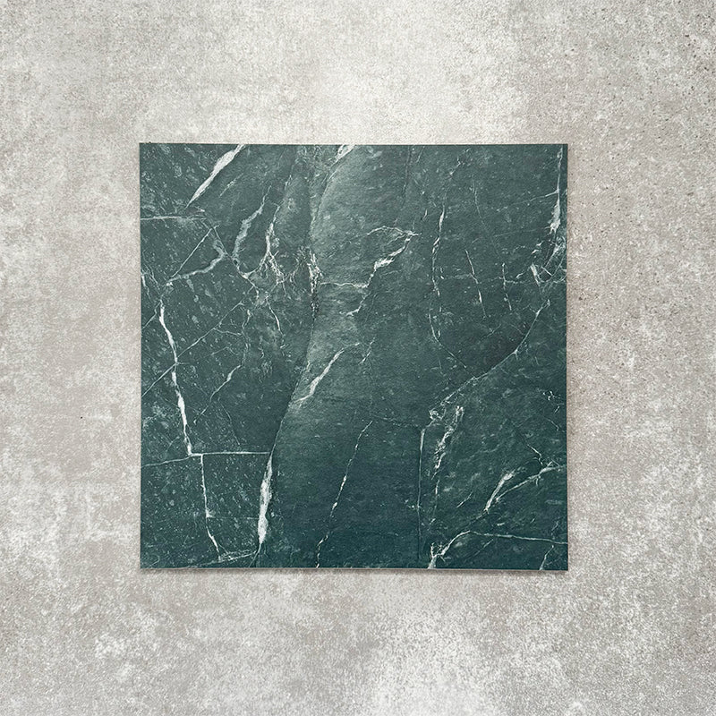 Close-up of Divine Verde Green matt marble-effect tile in a 30cm x 30cm format, featuring rich green tones with elegant white veining and natural marble-inspired movement. The bold stone effect creates a luxurious, timeless finish, making it ideal for statement chequerboard floors, feature areas and sophisticated interior schemes.