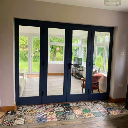 Doorway threshold featuring Cuba Patchwork Moroccan-style porcelain tiles in a 20×20cm square format, laid in a mixed patchwork design combining geometric and traditional motifs in earthy, green, blue and terracotta tones, creating a striking transition between indoor and outdoor spaces.