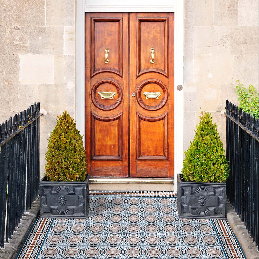 Front doorway featuring Imperial Victorian Blue Mini Tiles, 15x15cm porcelain tiles with a classic Victorian-inspired pattern, creating a decorative entrance floor beneath a traditional wooden door.