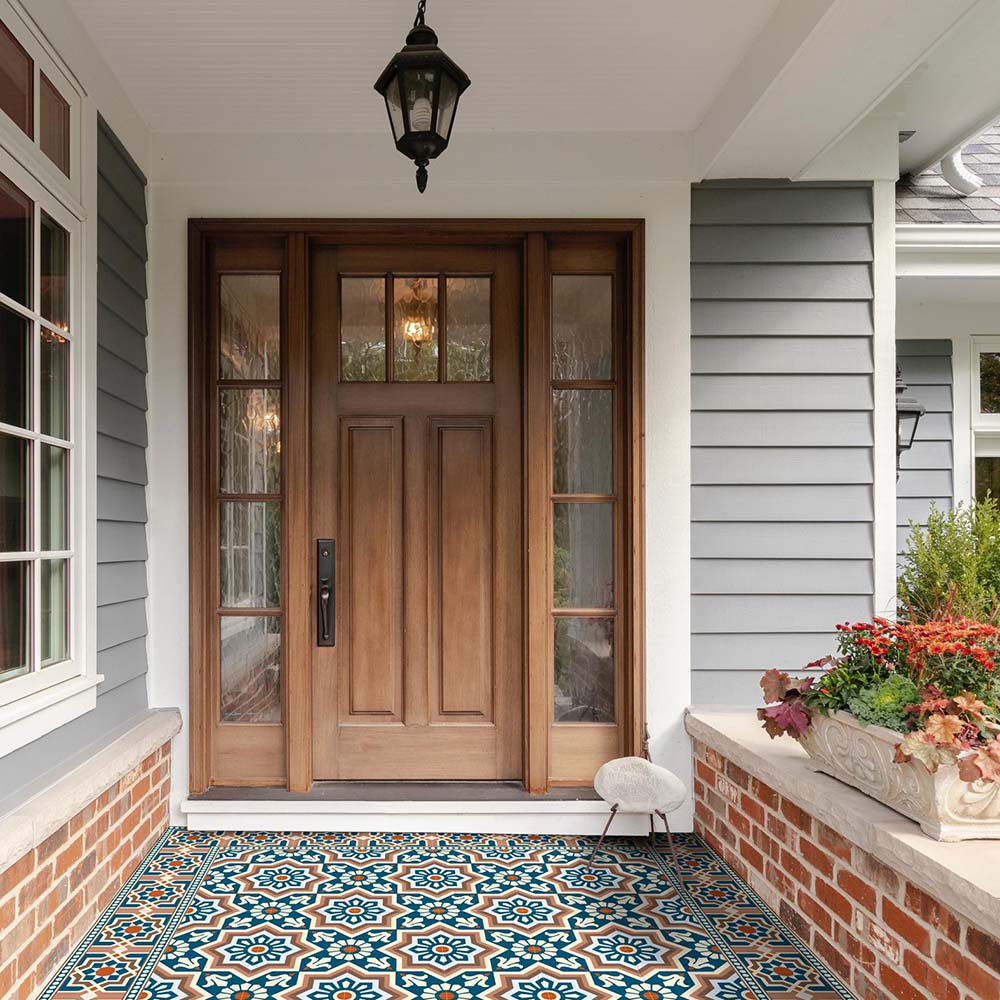 Front entrance featuring Balthazar Grand Side 20×20cm porcelain tiles used as a decorative porch floor, showcasing a bold Moroccan-inspired geometric border design in deep blue, warm brown and cream tones, creating a striking and welcoming doorway.