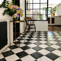 Entrance hallway featuring Florence Marquina Black 25x25cm marble-effect porcelain floor tiles, laid in a classic black and white checkerboard pattern and styled with industrial-style glazing, wooden furniture and soft neutral décor for a timeless, elegant look.