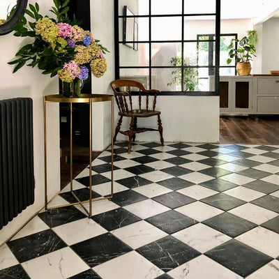 Entrance hallway featuring Florence Marquina Black 25x25cm marble-effect porcelain floor tiles, laid in a classic black and white checkerboard pattern and styled with industrial-style glazing, wooden furniture and soft neutral décor for a timeless, elegant look.