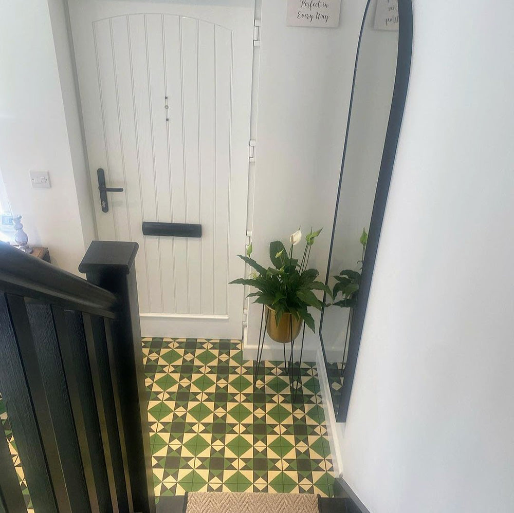 Bright hallway featuring Greenbrook Manor anti-slip encaustic Victorian-style porcelain floor tiles, laid in a classic green, black and cream geometric pattern, paired with white walls, a traditional console table and a painted timber front door.