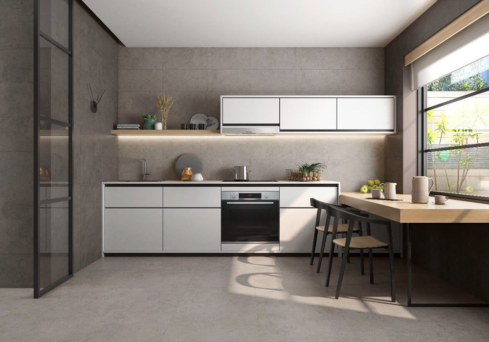 Kitchen interior featuring Etna Grey Matt 30 × 60cm porcelain wall and floor tiles, styled with white cabinetry, warm wood accents, open shelving, and natural light for a modern, balanced, contemporary space.