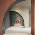 Interior walkway featuring Etna Marfil Matt 30 × 60cm porcelain floor tiles, styled with soft neutral tones, layered archways, and contrasting coloured walls to create a calm, architectural, contemporary space.